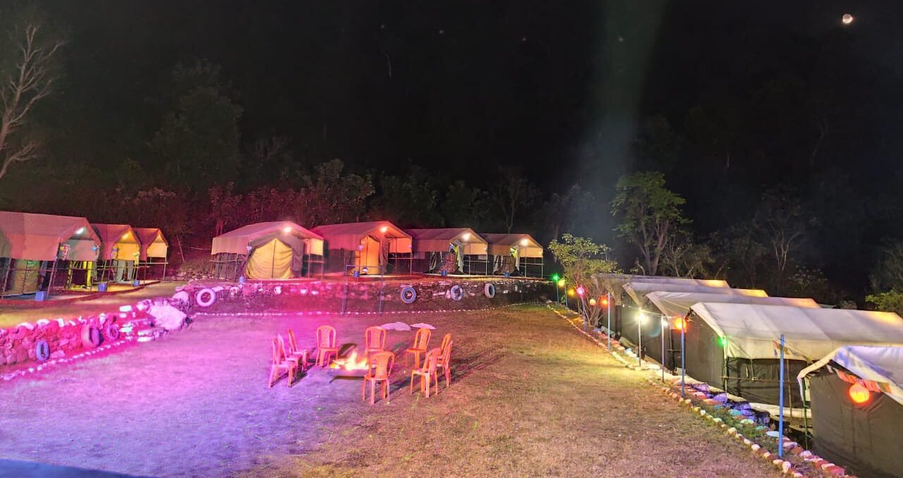 Camp lit up with colourful lights at night, camping in Rishikesh