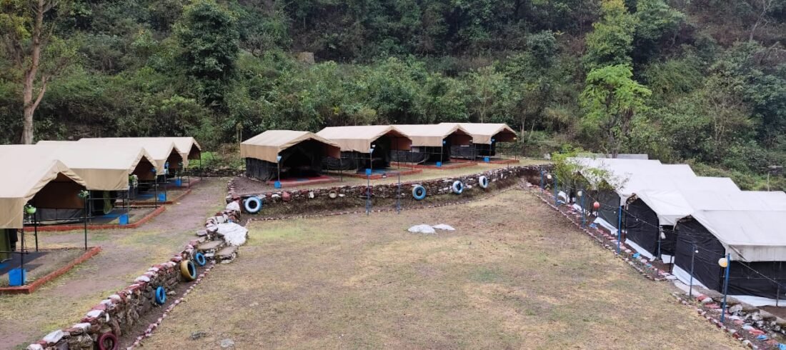 Wide view of the campsite and tents in the forest valley near Rishikesh